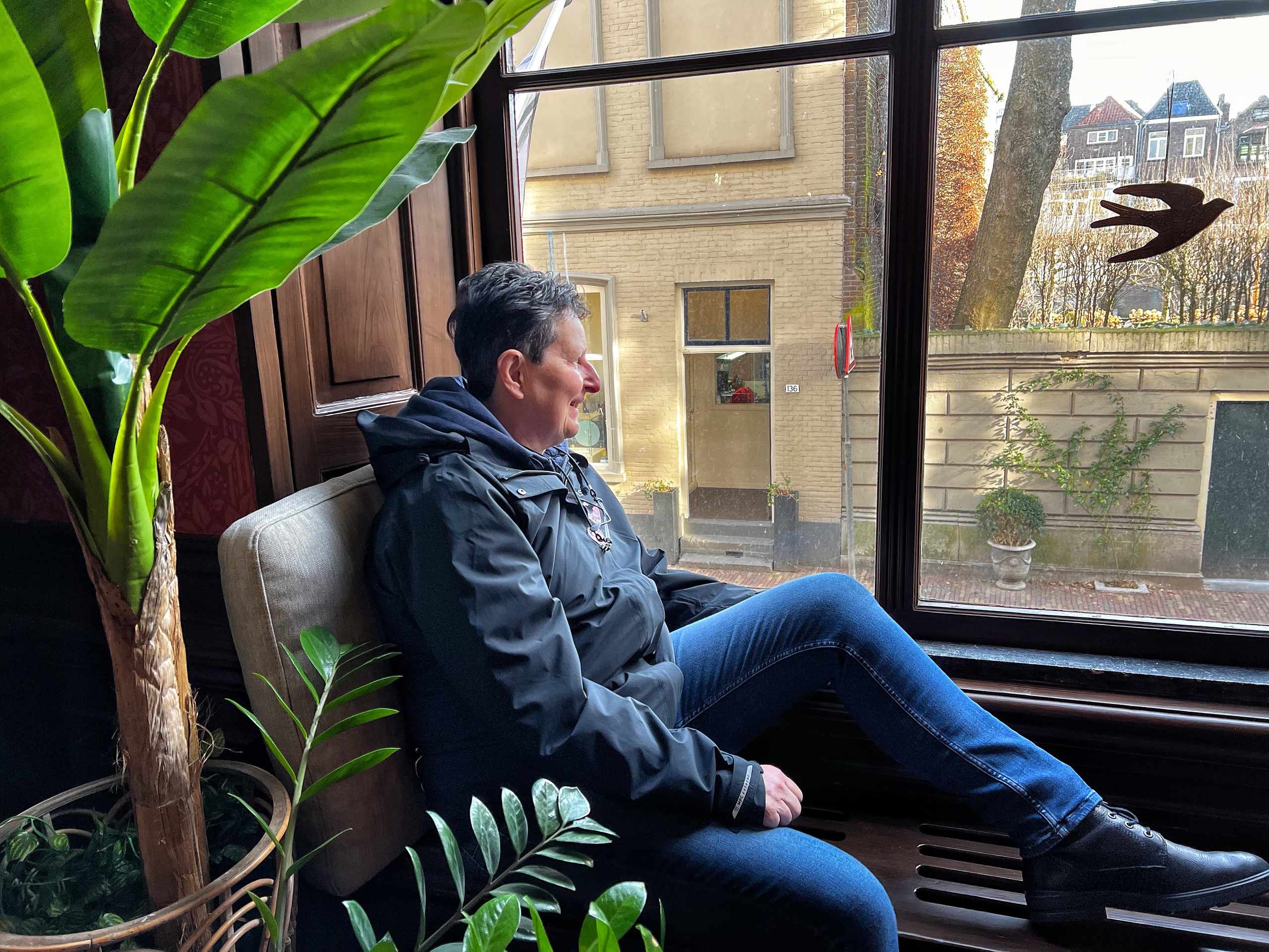 Adult seated by a window during a reflective interview