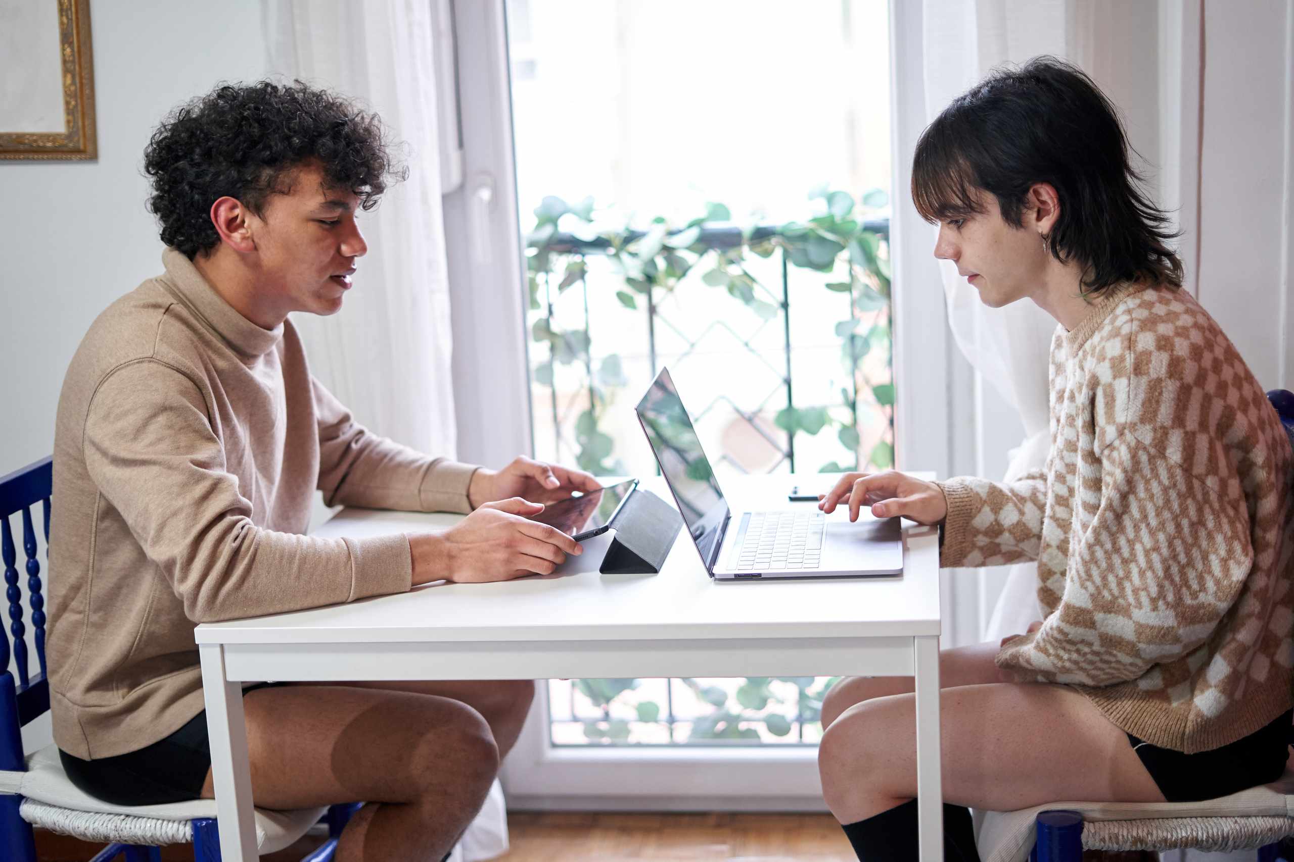 People preparing notes and equipment for a recorded conversation
